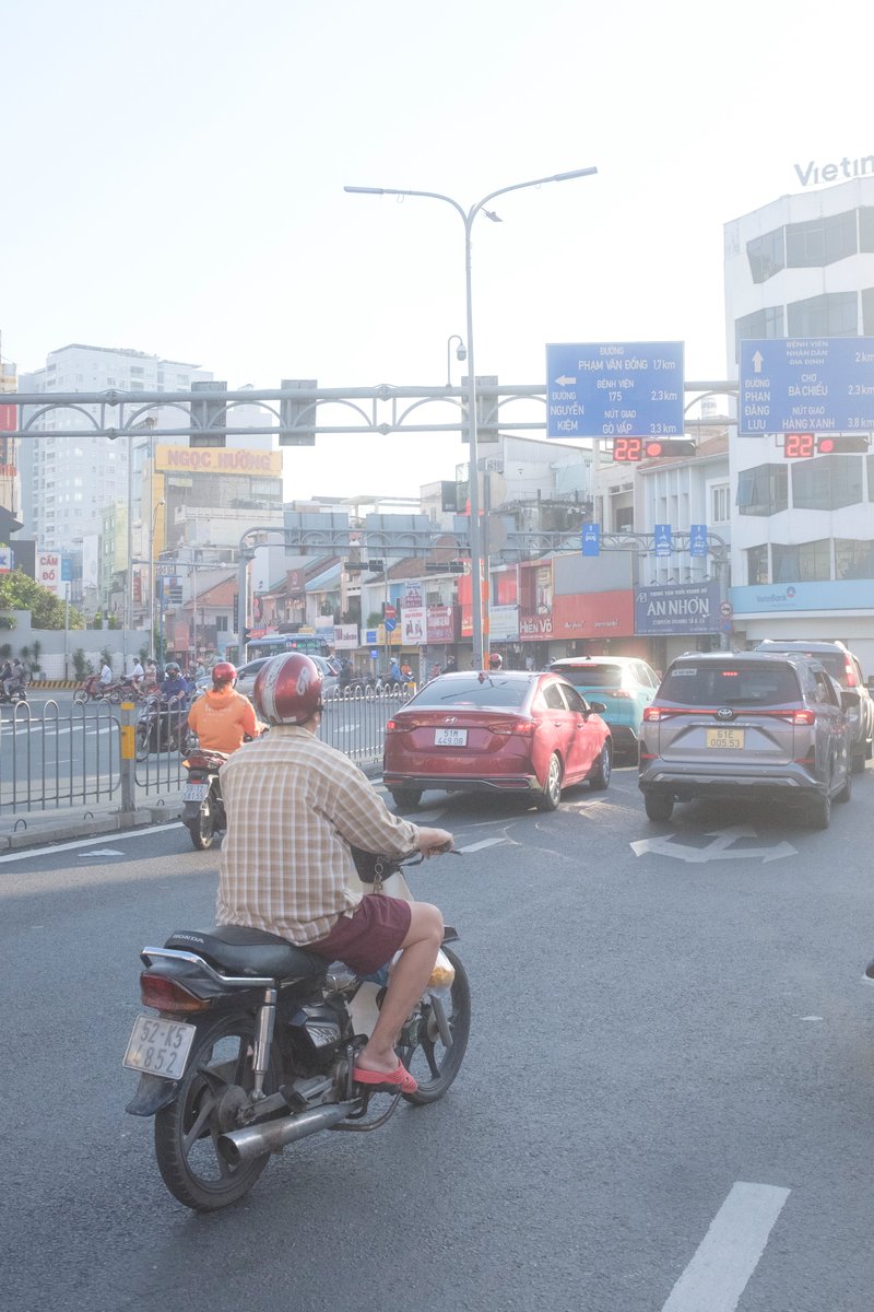 Edit city photo into rainy scene with Vietnamese bikers — output 1
